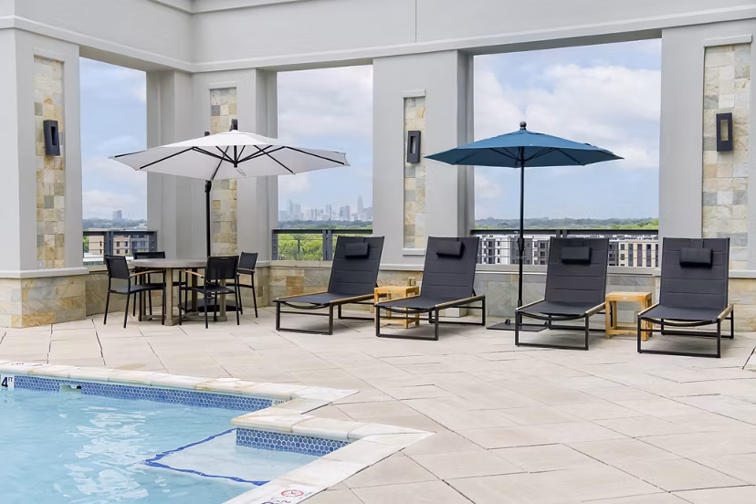 Luxury pool area with lounge seating at The Residence at SouthPark Apartments, perfect for relaxation and recreation