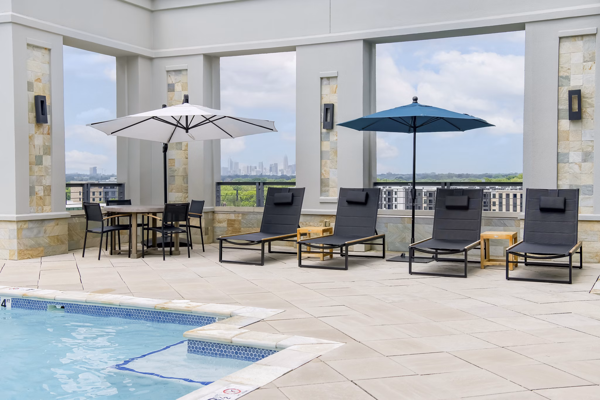 Luxury pool area with lounge seating at The Residence at SouthPark Apartments, perfect for relaxation and recreation