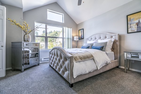 Spacious bedroom with modern decor in Avignon Townhomes Apartments, featuring large windows and neutral tones for a luxurious living experience
