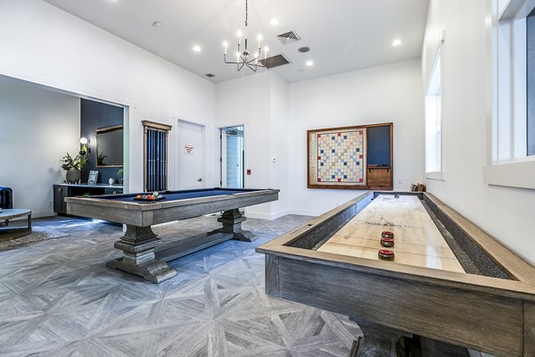 Clubhouse game room with pool table and lounge seating at Avignon Townhomes Apartments