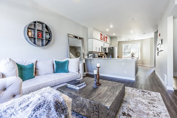 Living room with chic decor and natural lighting at Avignon Townhomes, luxury apartments by Greystar