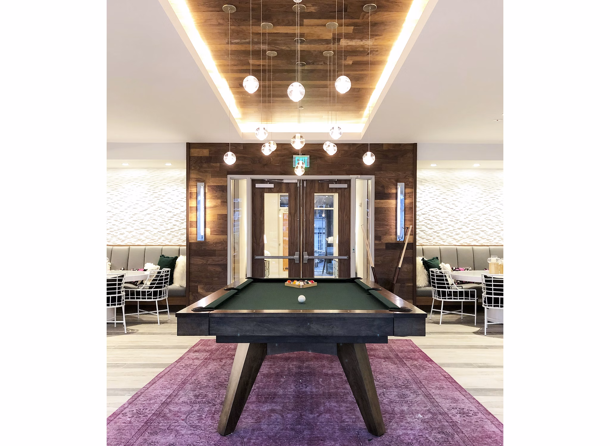 Game room with pool table and arcade games at Savoy Apartments