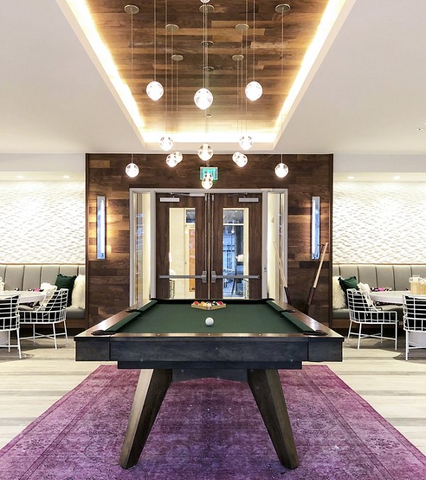 Game room with pool table and arcade games at Savoy Apartments
