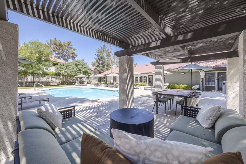 Outdoor pool and patio at Sage at Green Valley Apartments featuring lounge chairs and lush landscaping