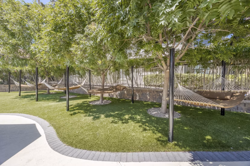 Hammock area on patio at Sage at Green Valley Apartments, luxury outdoor space nearby dining and leisure behind high-rise living