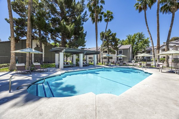 Resort-style pool surrounded by lush landscaping at Sage at Green Valley Apartments