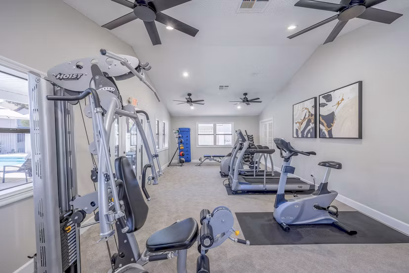 Fully-equipped fitness center at 5400 Vistas Apartments offering modern exercise machines and open workout spaces