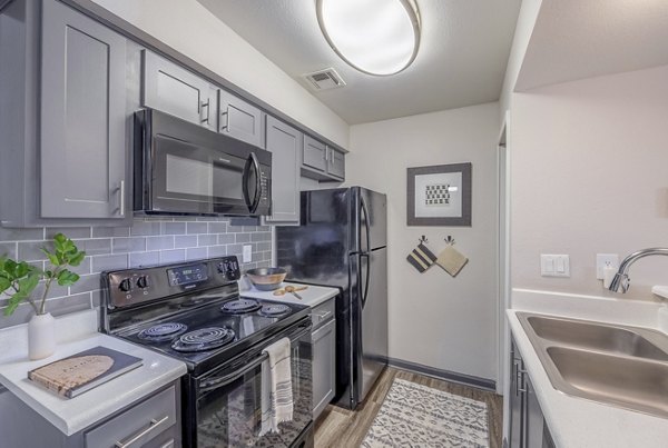 Modern kitchen with stainless steel appliances at 5400 Vistas Apartments