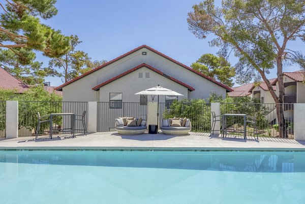Poolside relaxation area at 5400 Vistas Apartments with lounge chairs and umbrellas, perfect for enjoying luxury outdoor amenities