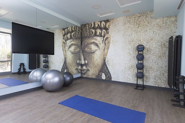 Yoga and spin studio featuring mirrored walls and natural light at One Beachmont Apartments