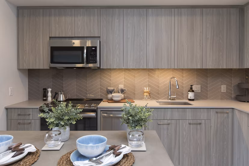 Modern kitchen featuring stainless steel appliances in One Beachmont Apartments