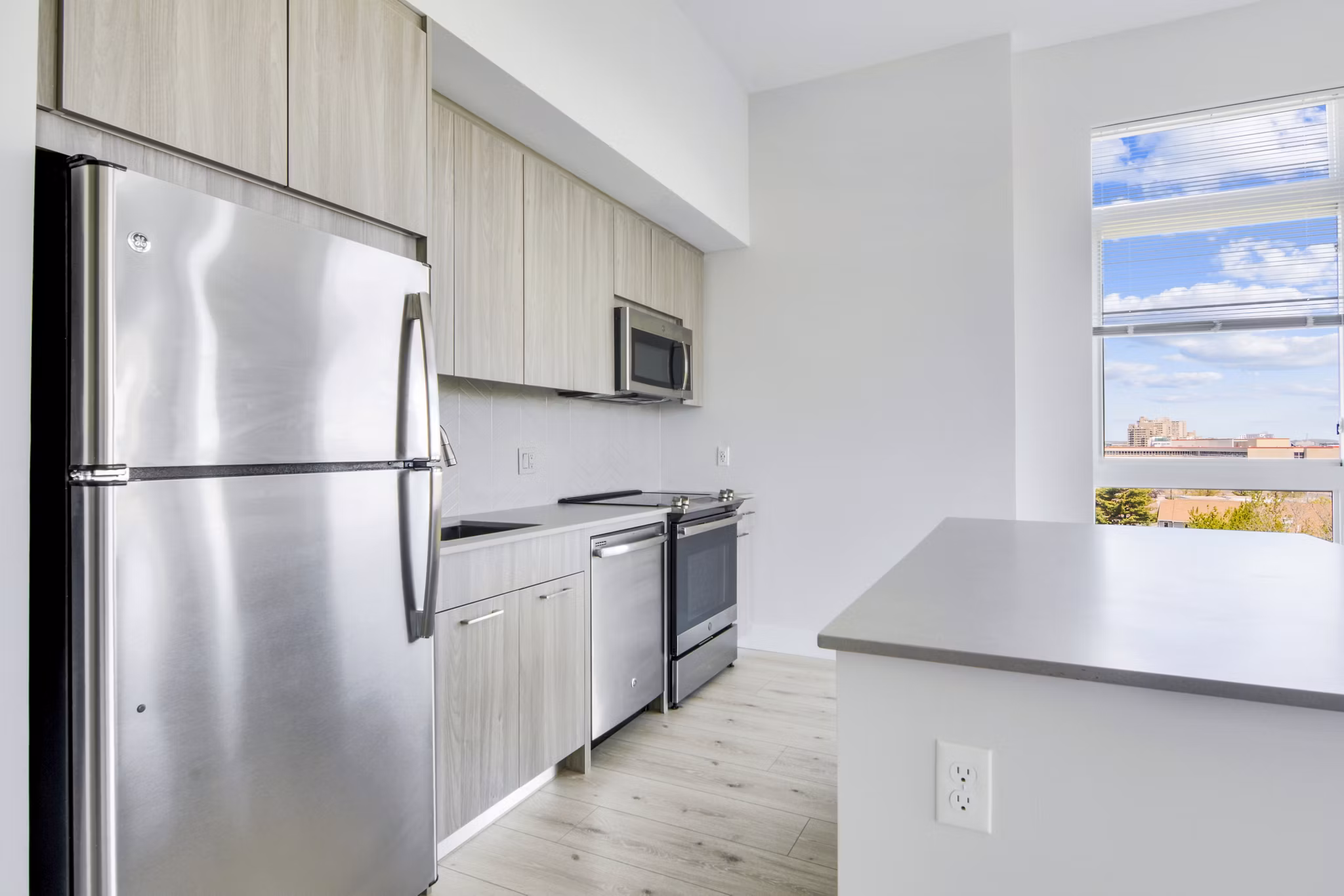 Modern kitchen with sleek countertops and stainless steel appliances in One Beachmont Apartments, Revere MA
