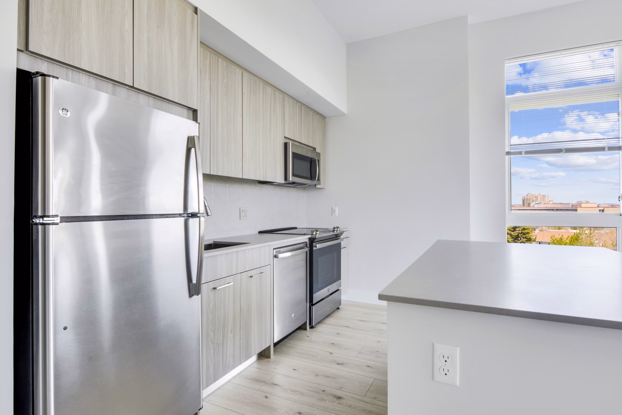 Modern kitchen with sleek countertops and stainless steel appliances in One Beachmont Apartments, Revere MA