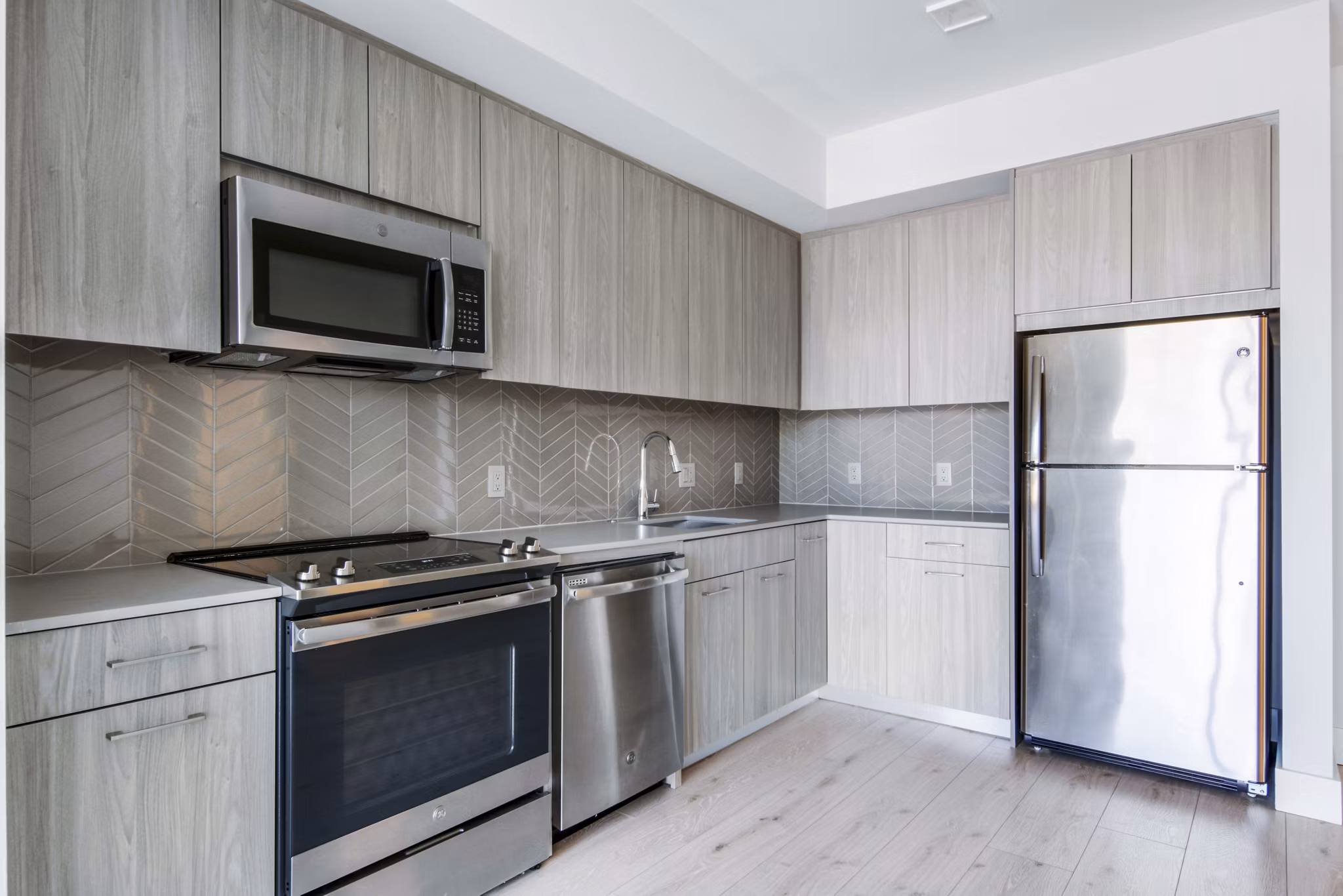 Modern kitchen with stainless steel appliances at One Beachmont Apartments luxury residences