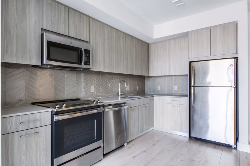 Modern kitchen with stainless steel appliances at One Beachmont Apartments luxury residences