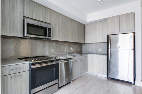 Modern kitchen with stainless steel appliances at One Beachmont Apartments luxury residences