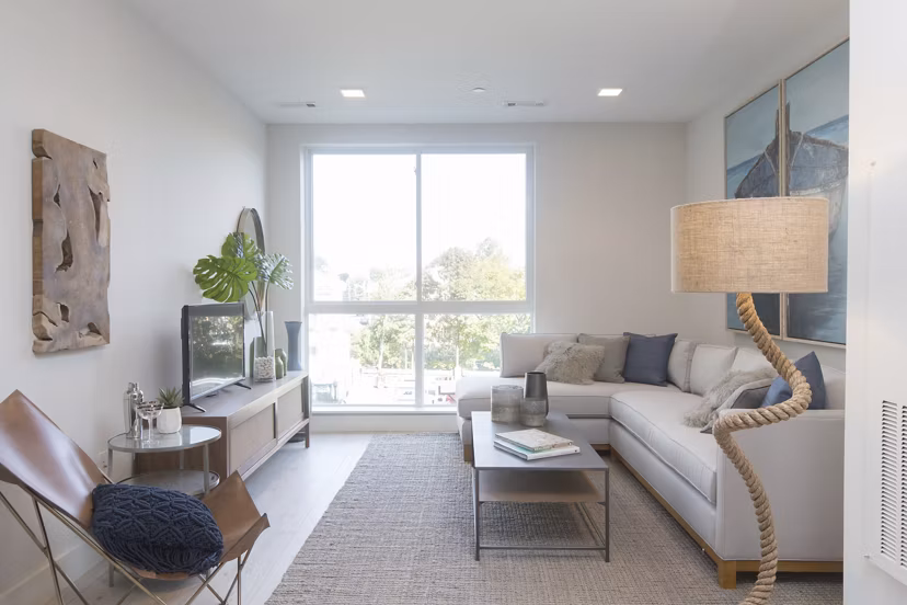 Modern living room with ocean views at One Beachmont Apartments, featuring stylish furnishings and natural light in a luxury setting