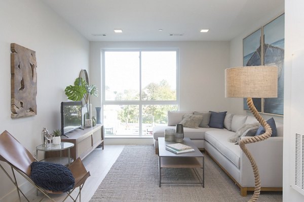 Modern living room with ocean views at One Beachmont Apartments, featuring stylish furnishings and natural light in a luxury setting