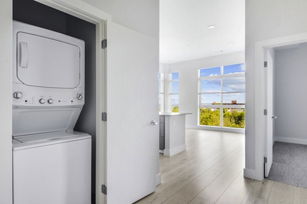 Laundry room featuring modern appliances at One Beachmont Apartments