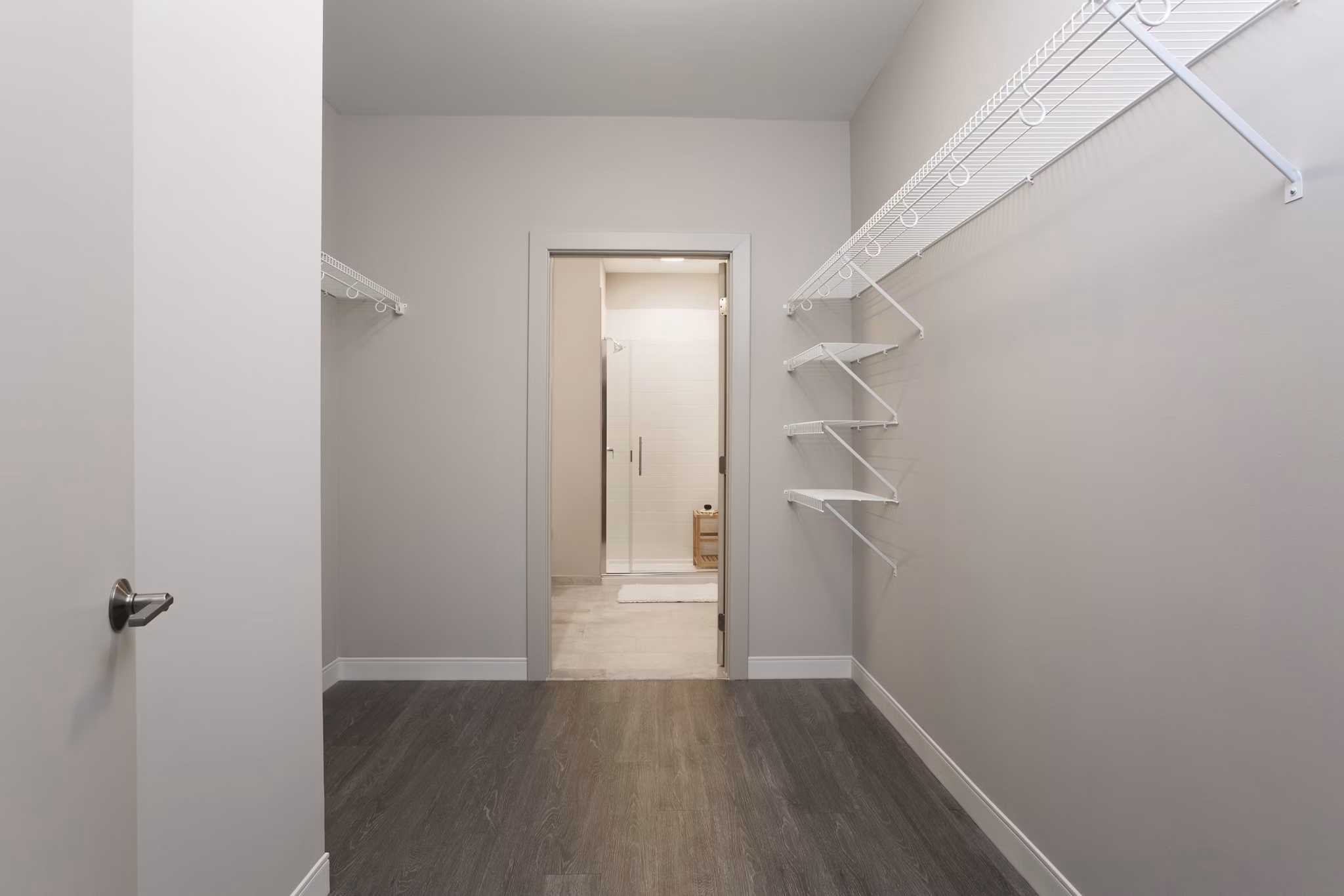 Walk-in closet with custom shelving and ample storage at The Andi Apartments