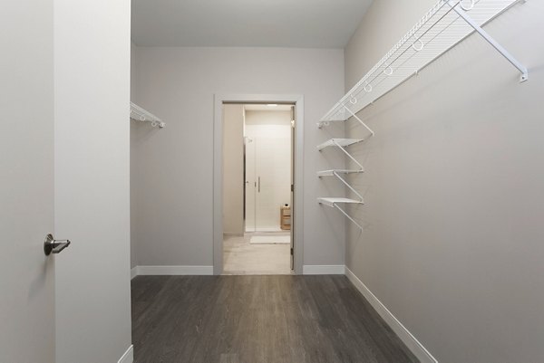 Walk-in closet with custom shelving and ample storage at The Andi Apartments