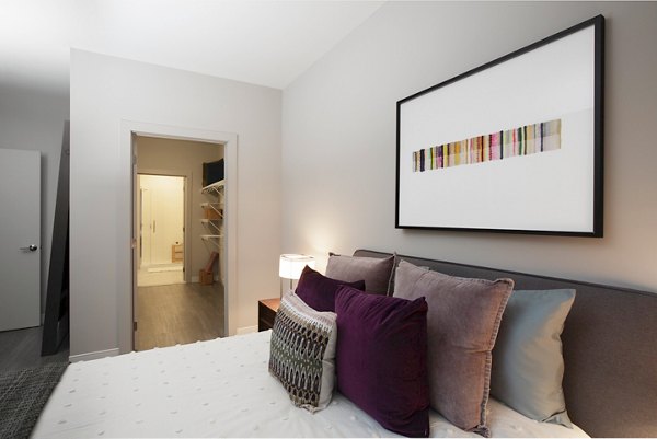 Modern bedroom with plush bedding at The Andi Apartments in Boston