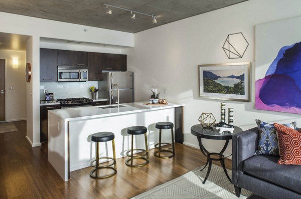 Modern kitchen with sleek countertops and stainless-steel appliances in Indigo at Twelve West Apartments
