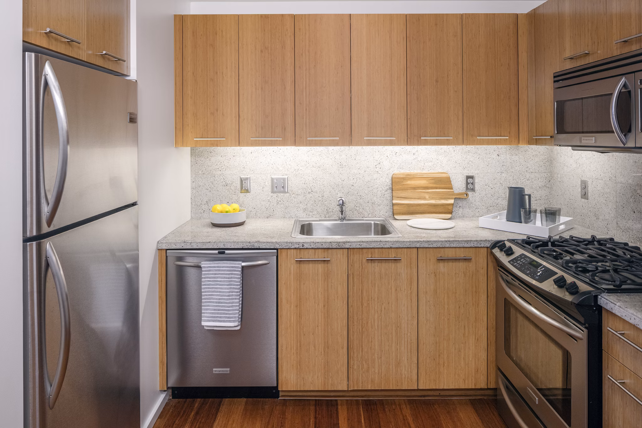 Modern kitchen with stainless steel appliances at Indigo at Twelve West Apartments
