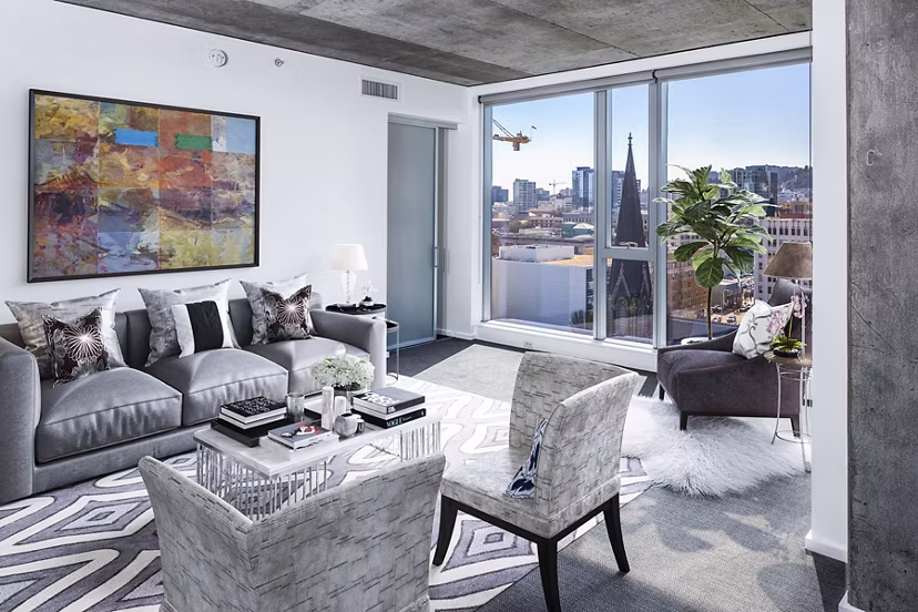 Cozy living room with modern decor and ample natural light at Indigo at Twelve West Apartments