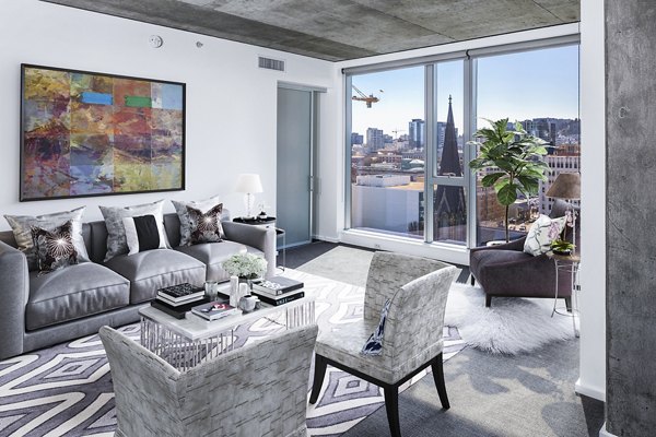 Cozy living room with modern decor and ample natural light at Indigo at Twelve West Apartments