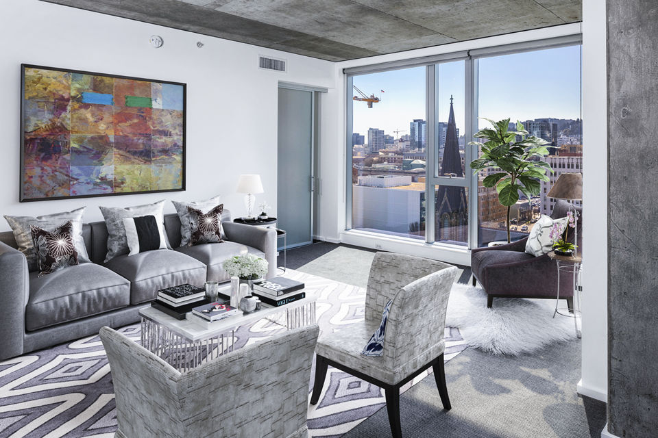 Cozy living room with modern decor and ample natural light at Indigo at Twelve West Apartments