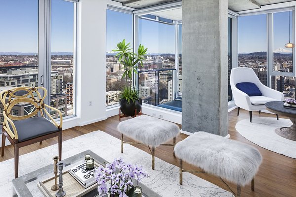 Living room with modern decor and large windows at Indigo at Twelve West Apartments, offering luxury living in a Greystar community