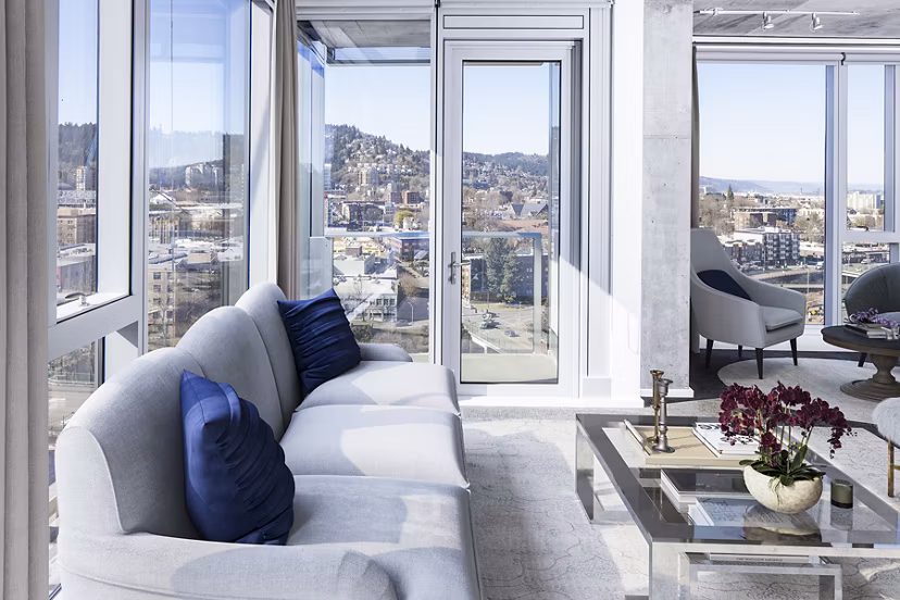 Modern living room with sleek furniture and large windows at Indigo at Twelve West Apartments in Portland