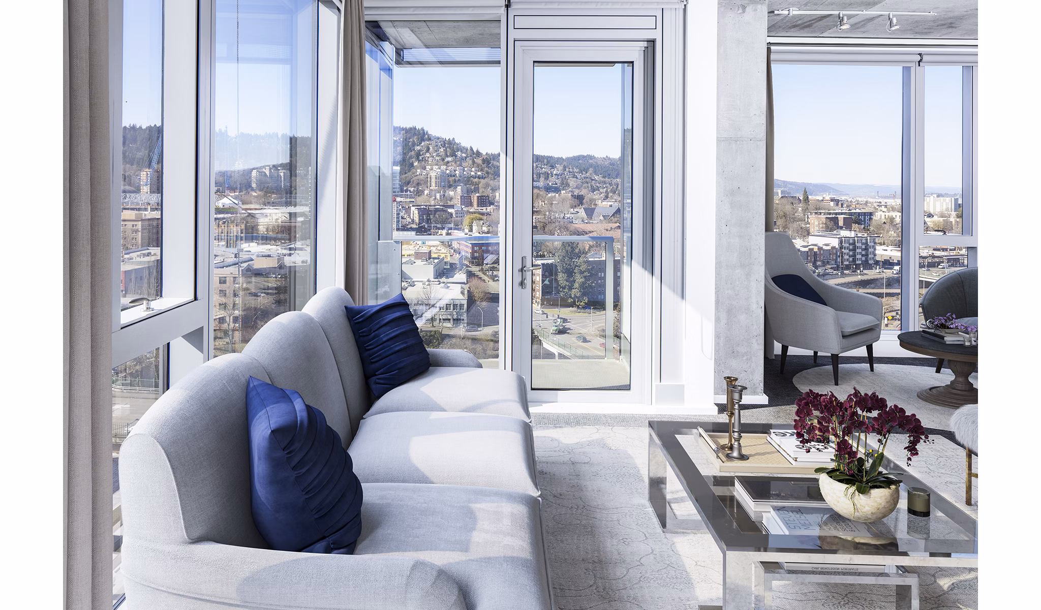 Modern living room with sleek furniture and large windows at Indigo at Twelve West Apartments in Portland