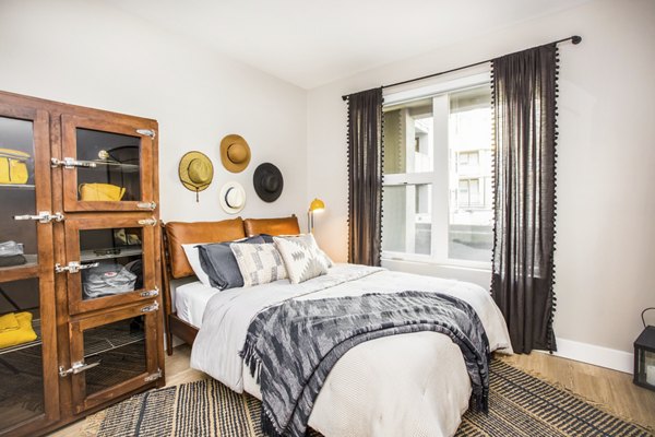 Bedroom featuring modern design and plush bedding at Fourth Street East Apartments