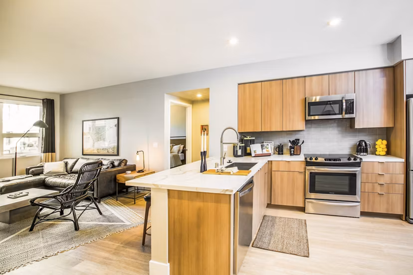 Modern kitchen featuring stainless steel appliances and granite countertops at Fourth Street East Apartments