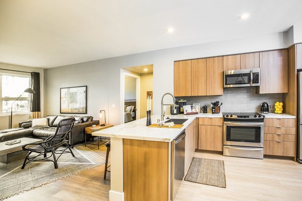 Modern kitchen featuring stainless steel appliances and granite countertops at Fourth Street East Apartments