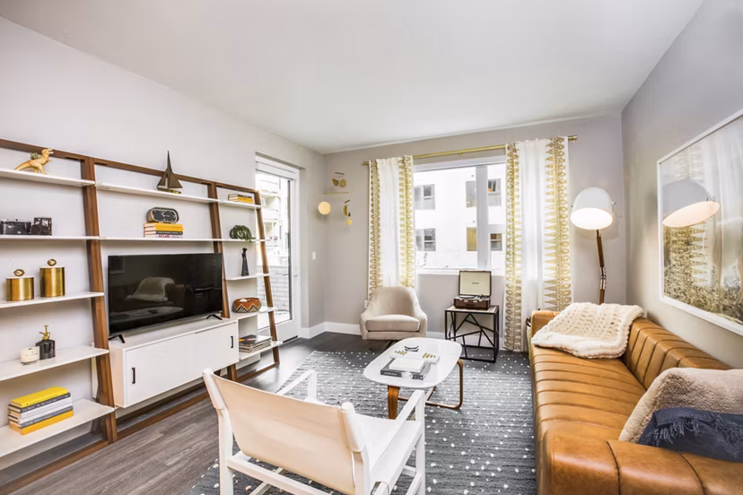 Open living room with modern decor and large windows at Fourth Street East Apartments
