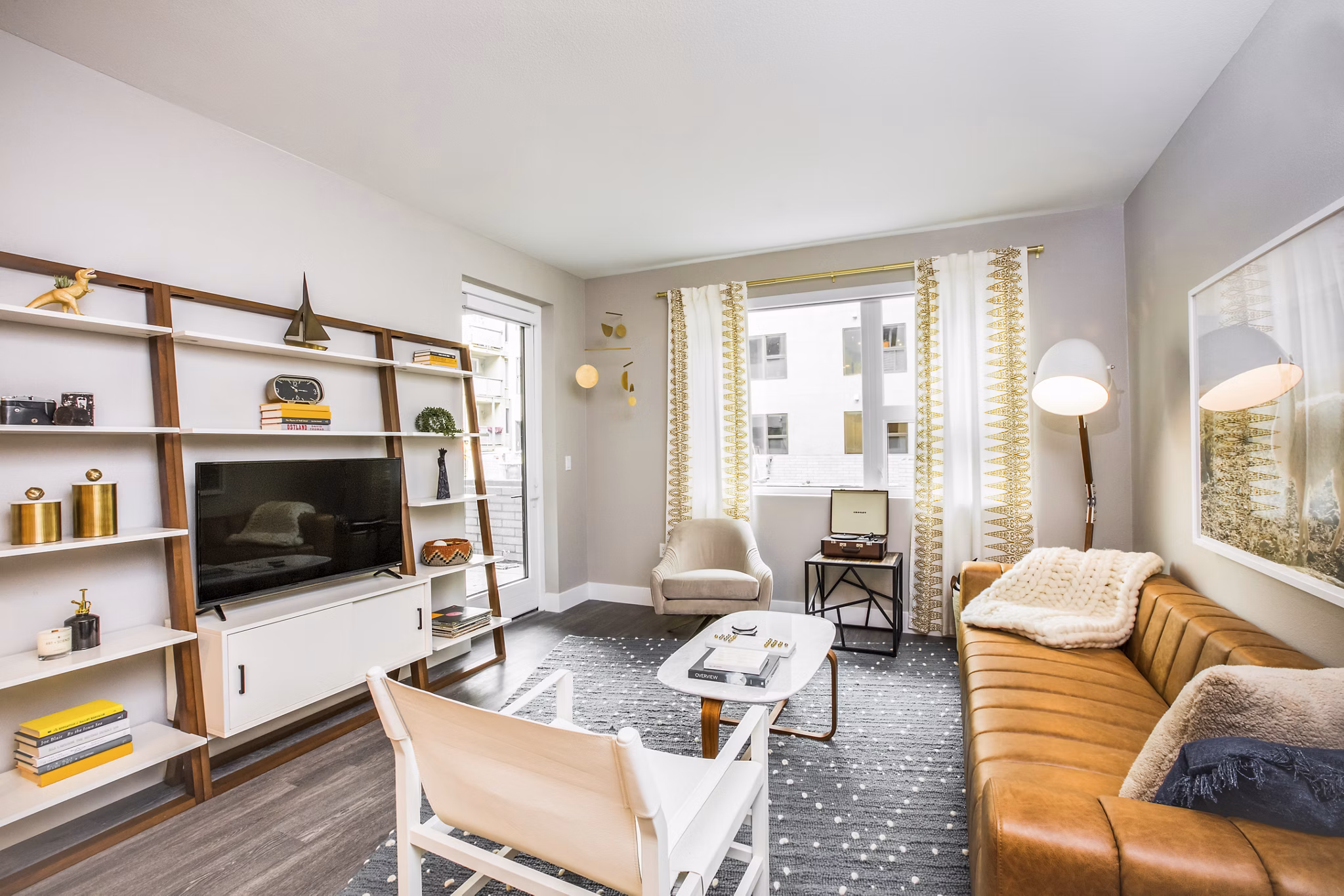 Open living room with modern decor and large windows at Fourth Street East Apartments