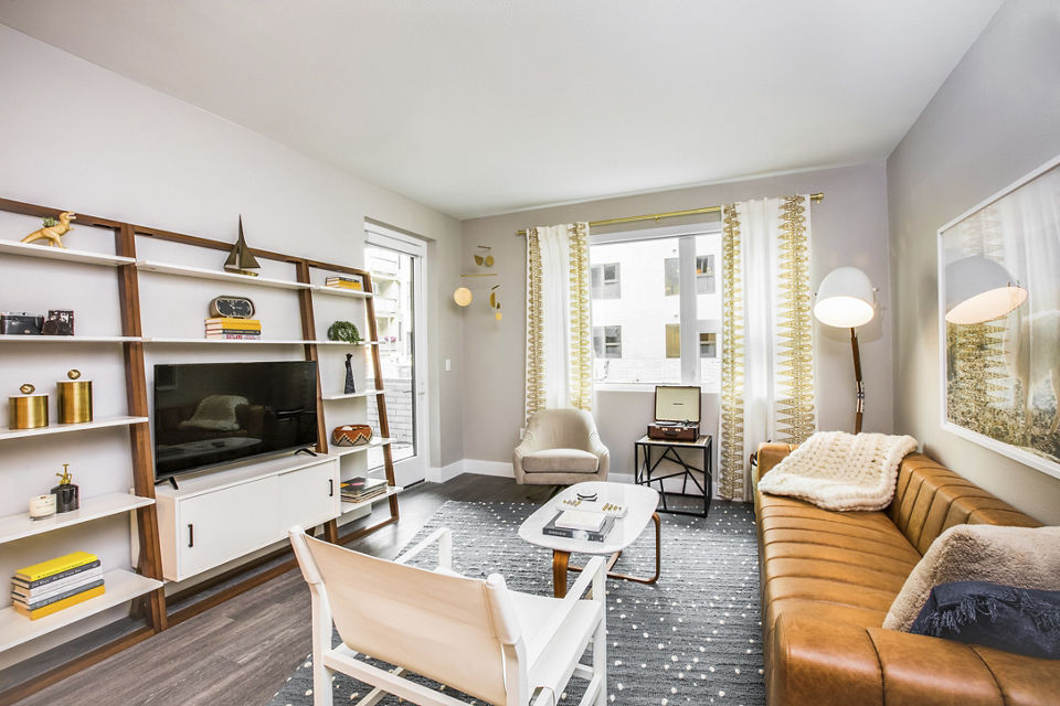 Open living room with modern decor and large windows at Fourth Street East Apartments