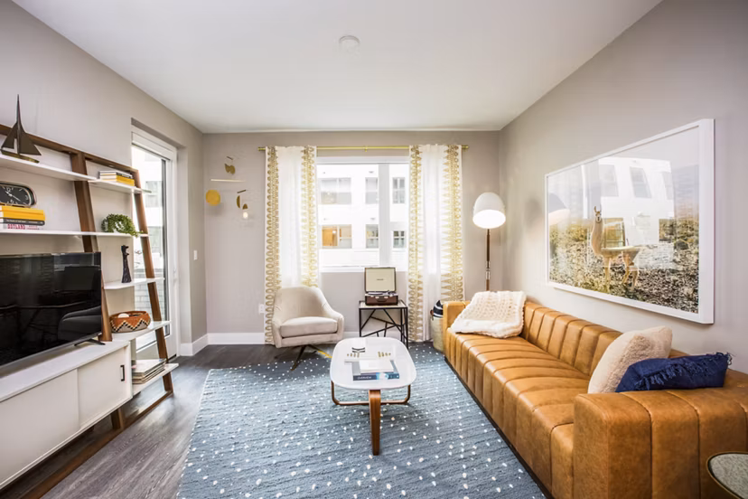 Modern living room with elegant furnishings and large windows at Fourth Street East Apartments