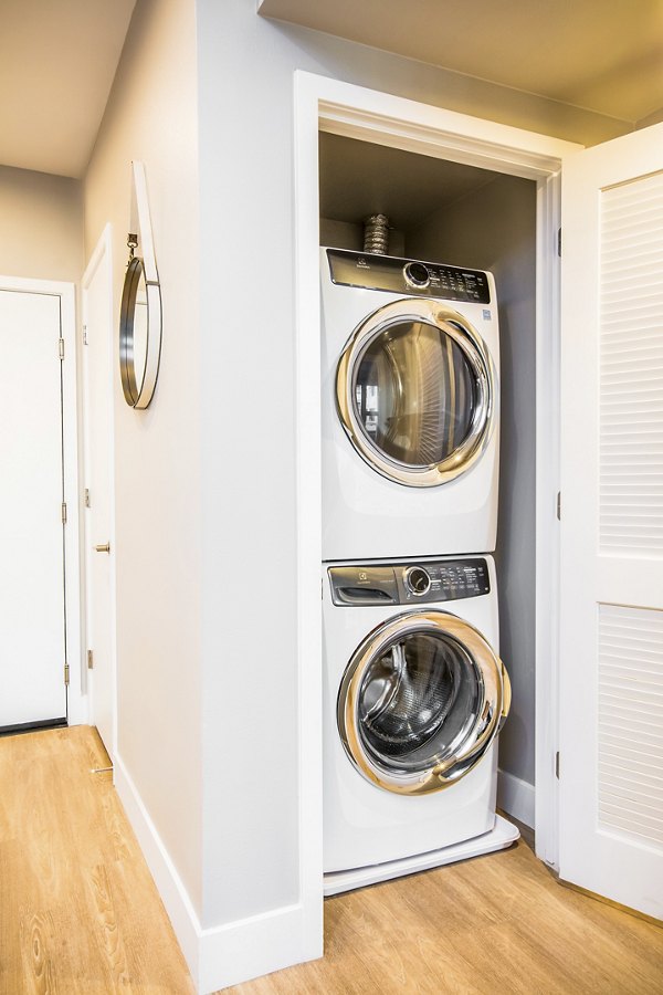 Modern laundry room with high-efficiency washers and dryers at Fourth Street East Apartments