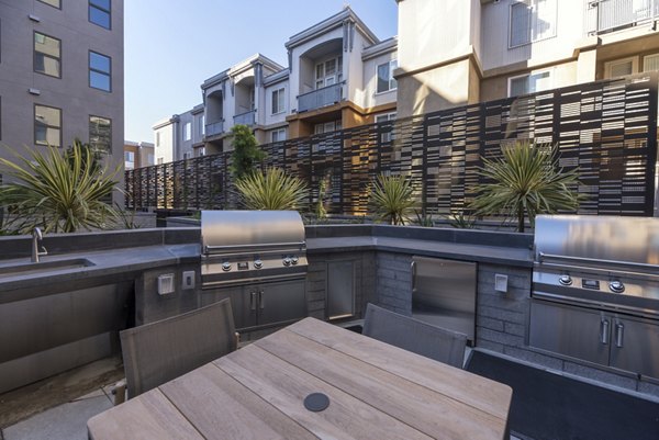 Outdoor grill area with modern seating at Fourth Street East Apartments, perfect for social gatherings and dining in the heart of the community