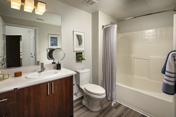 Bathroom featuring elegant marble countertops and luxury fixtures at The District Apartments