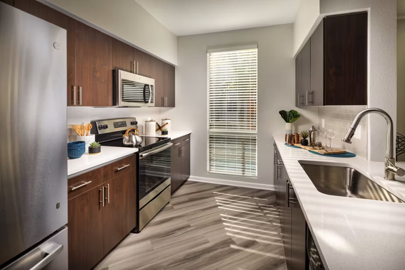 Modern kitchen with stainless steel appliances in The District Apartments