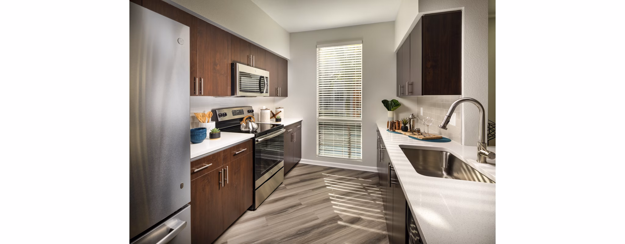 Modern kitchen with stainless steel appliances in The District Apartments