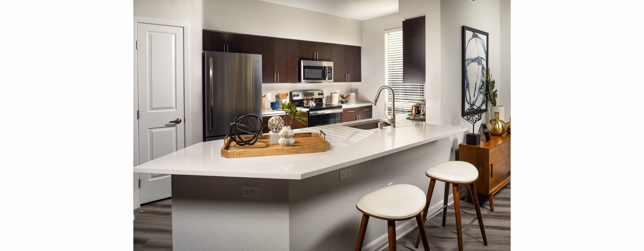 Kitchen showcasing sleek countertops and stainless steel appliances at The District Apartments