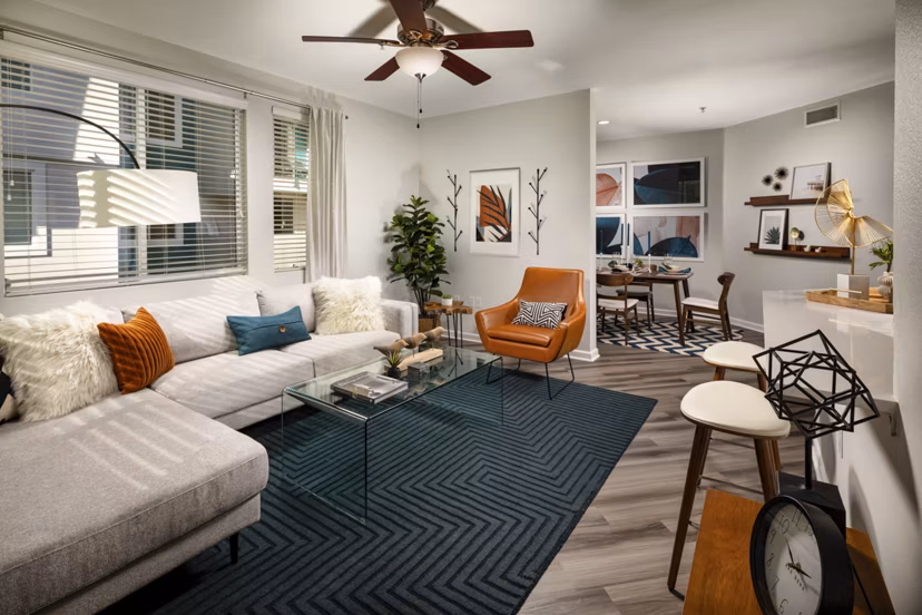 Spacious living room with modern furnishings and large windows at The District Apartments
