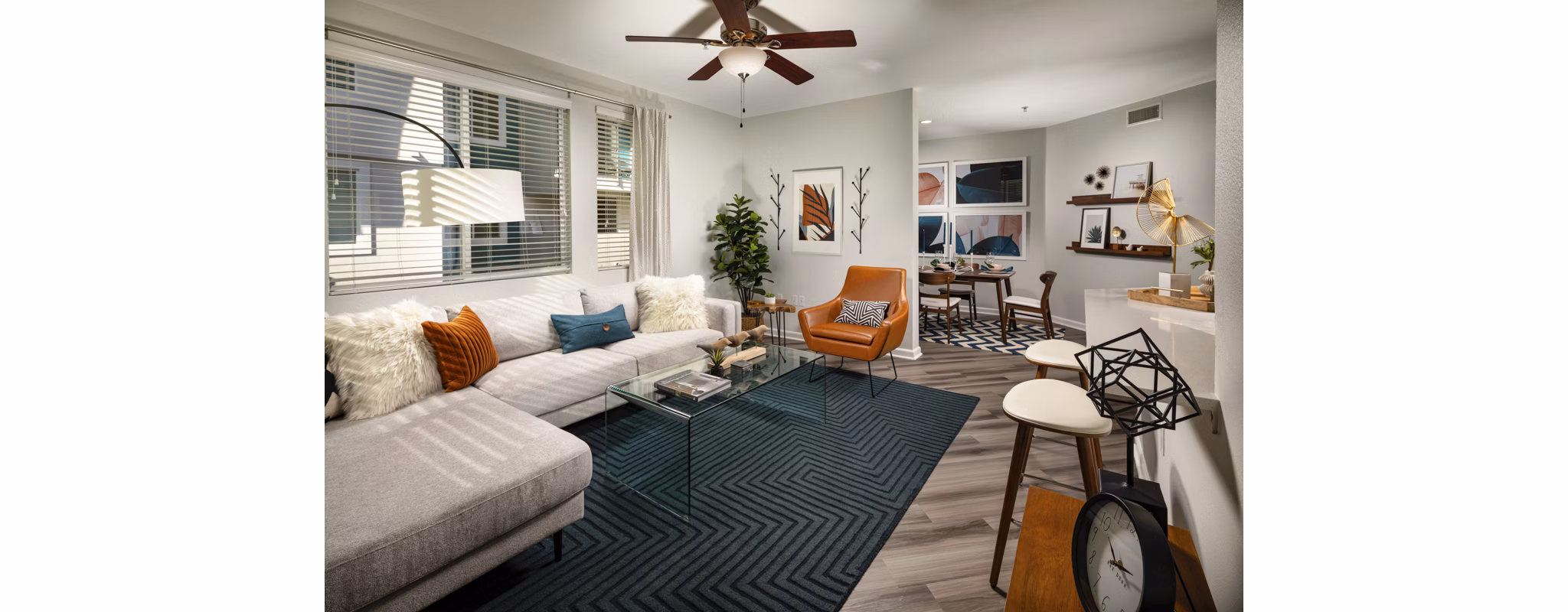 Spacious living room with modern furnishings and large windows at The District Apartments
