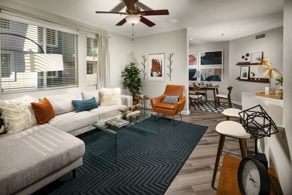 Spacious living room with modern furnishings and large windows at The District Apartments